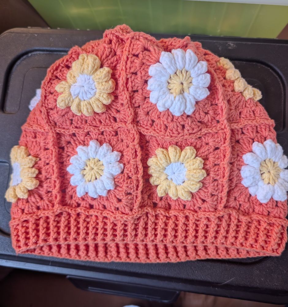 Crochet hat in orange with yellow and white flower squares