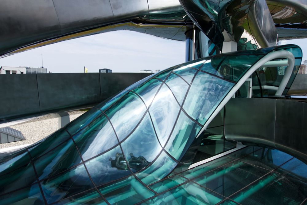 Boven op het dak van het museum een foto van het deels gebogen glas dat een deel van de trap bedekt