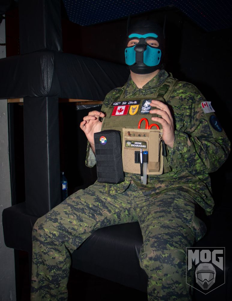 Sir Divik standing on a ledge in digital camo and a plate carrier
