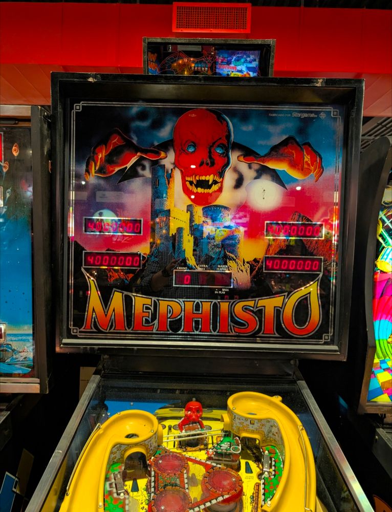Mephisto backglass.  Red fanged skull with hands.