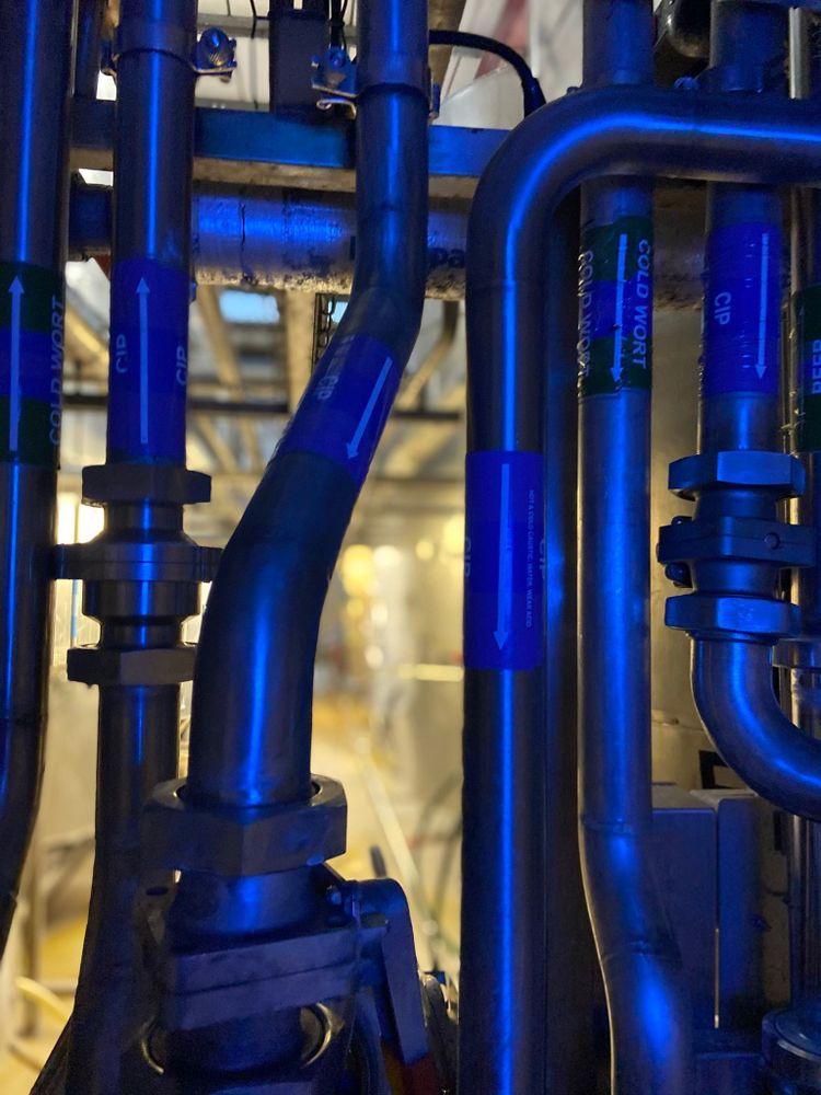 A close up of the brewery kit, the interconnected pipes lit by blue light.