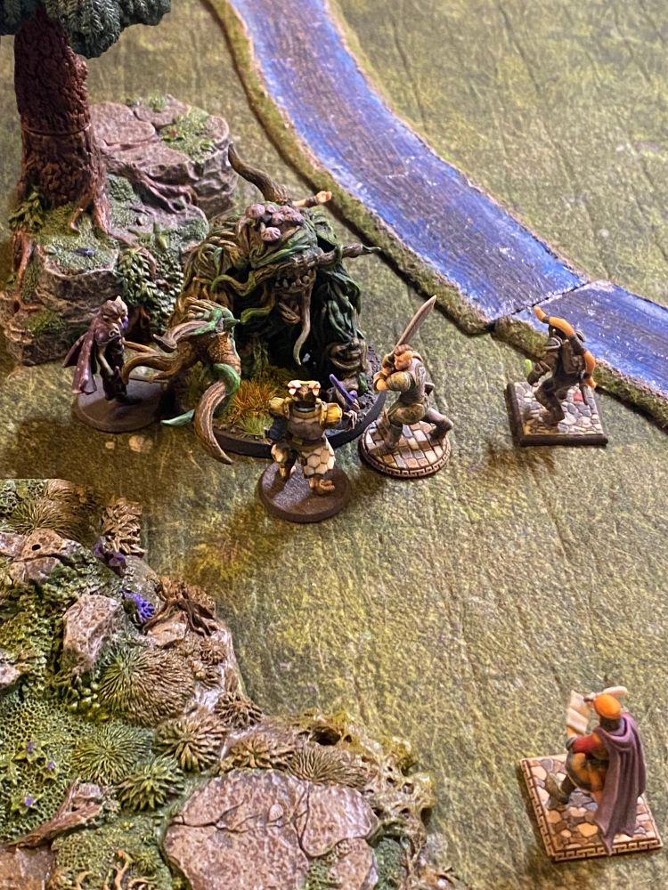 D&D minis of our party around a shambling plant monster mini.