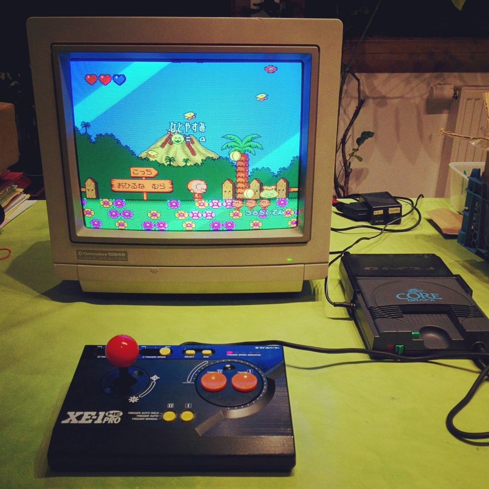 A PC Engine hooked up to a monitor with an arcade joystick 