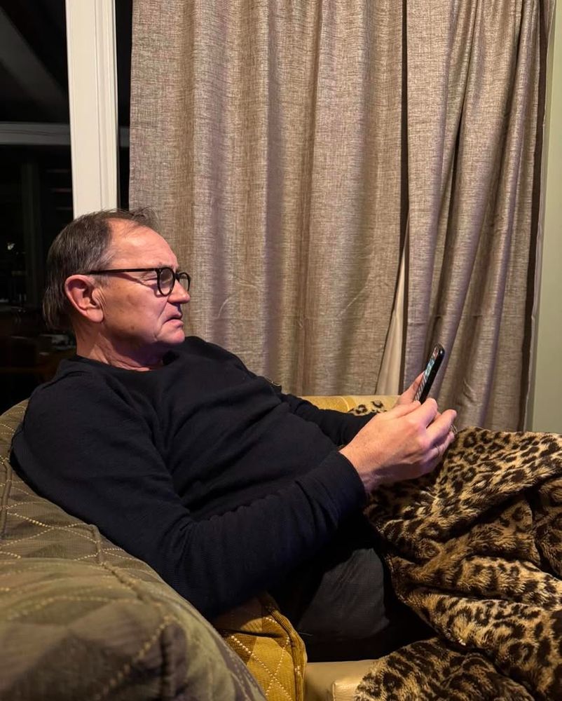 Ewald Lienen guckt skeptisch auf sein Handy.