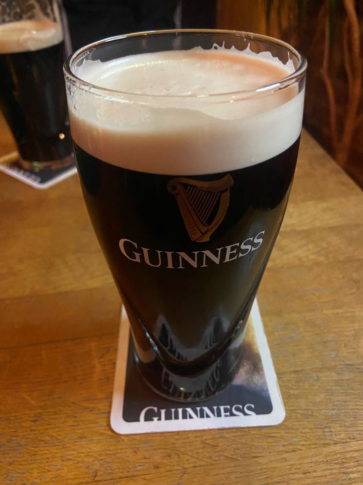 Ein Pint Guinness auf einem Bierdeckel auf dem „Guinness“ steht