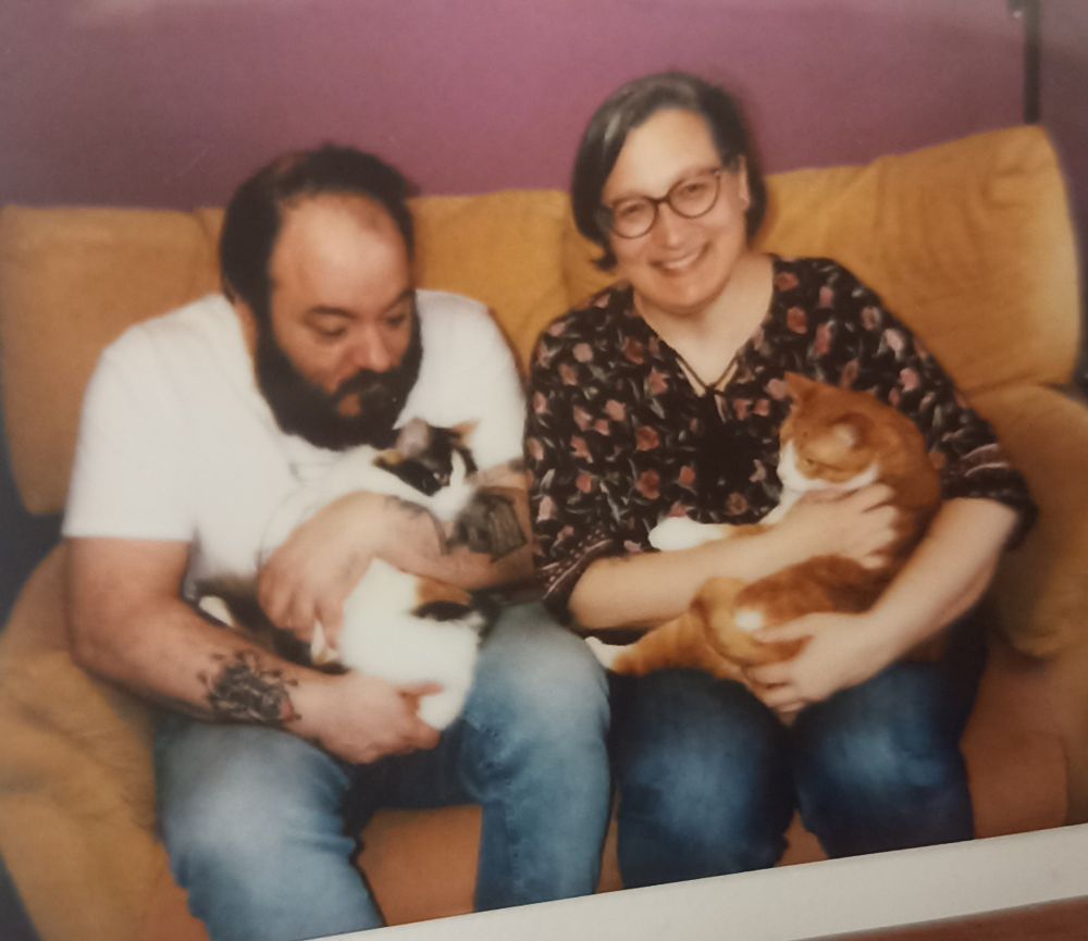 Handsome bearded guy holding our Calico cat and myself holding our tabby ginger cat.