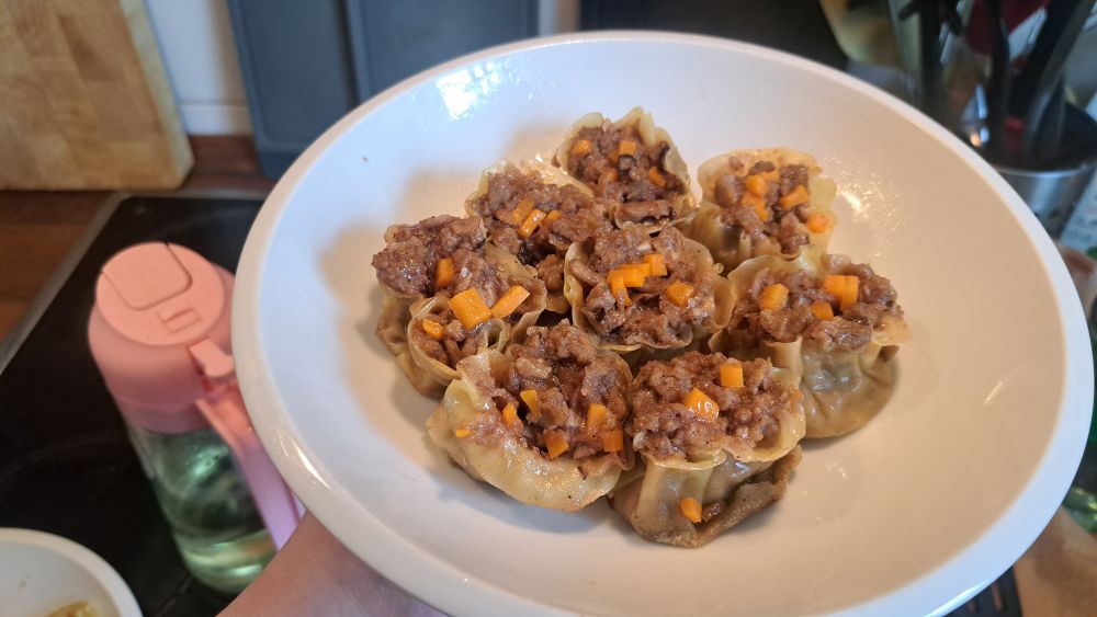 a plate of cooked siu mai dumplings