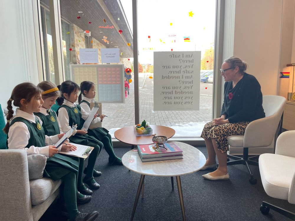 A group of four Grade 1 students interview Ms. White in her office.