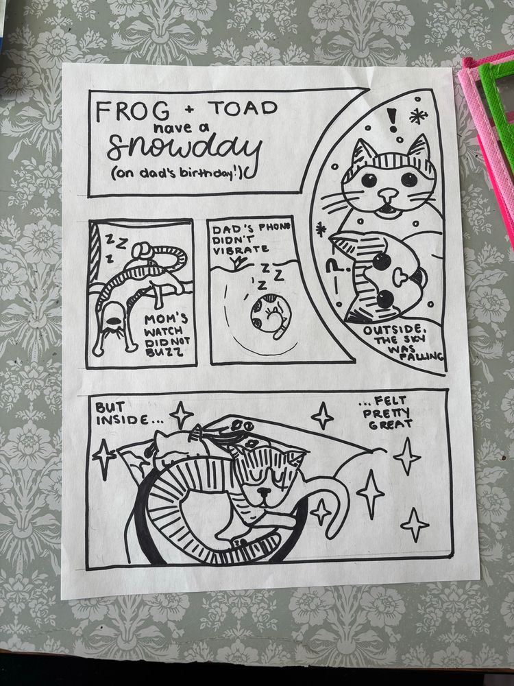 Comic: 
Panel 1: Frog and Toad have a snow day (on dad’s birthday!)
Panel 2: a person with a bun in bed with a cat asleep on her face “mom’s watch did not buzz”
Panel 3: a person with a little ponytail in bed, totally covered by the blanket, with a different cat asleep on top of them “dad’s phone didn’t vibrate”
Panel 4: the same two cats looking confused and alarmed as snow falls before them “outside the sky was falling”
Panel 5: the two cats snuggling each other with two, tattooed arms around them, also holding onto each other “but inside felt pretty great”