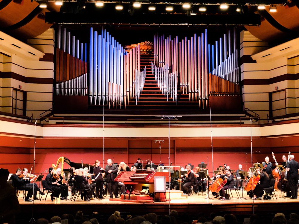 Beautiful set of multicolored pipes surrounding what looks like a staircase. It almost appears like a backdrop on a stage behind an orchestra