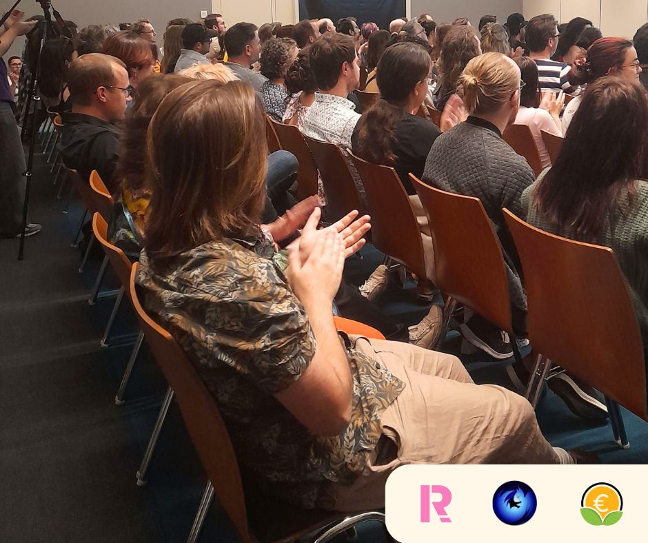 Photo de la salle, le public est en train d'applaudir. On voit le public de dos.