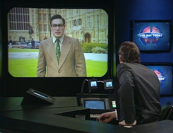 Bumbling incompetent interviewer 'Peter O'Hanrahanrahan' gets chewed out by Chris Morris' newsreader on British journalism satirical comedy television show The Day Today via a big studio television screen. He's just lost the news.