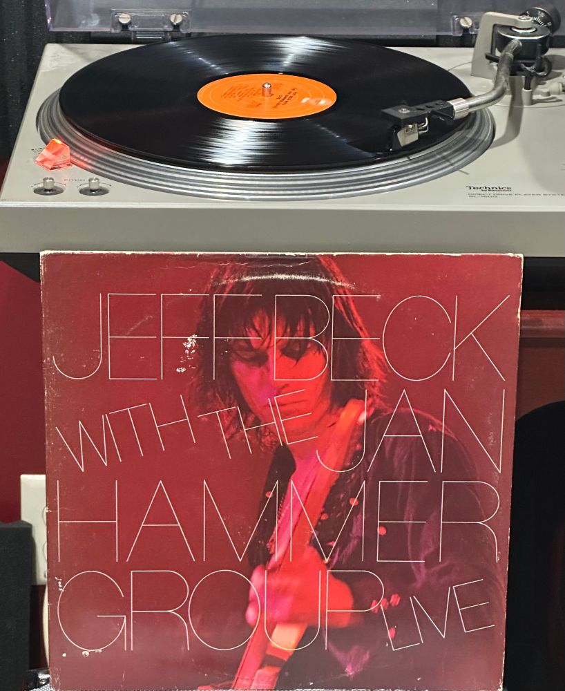 Album cover of Jeff Beck playing a Fender Stratocaster guitar. Above the cover is the vinyl on a turntable. 