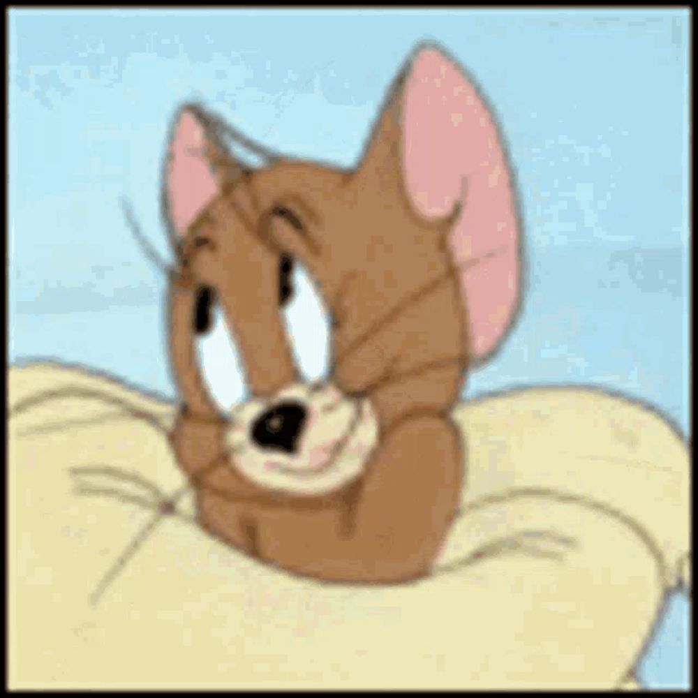 jerry from tom and jerry is laying on a pillow on a bed .