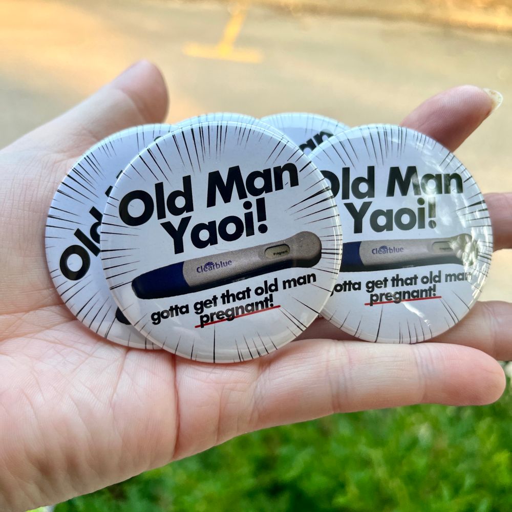 bendy holding buttons that say “Old Man Yaoi!” with a positive pregnancy test underneath. Underneath that it says “gotta get that old man pregnant!” and pregnant is underlines in red.