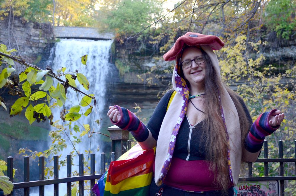 kate modeling the brown shroom cap with silver spots next to minnehaha falls
