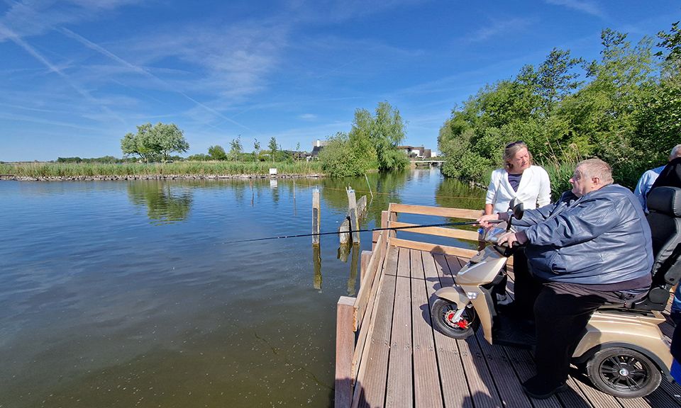 Meneer in scootmobiel maakt gebruik van de nieuwe vissteiger aan de Nieuwkoopse Plassen.