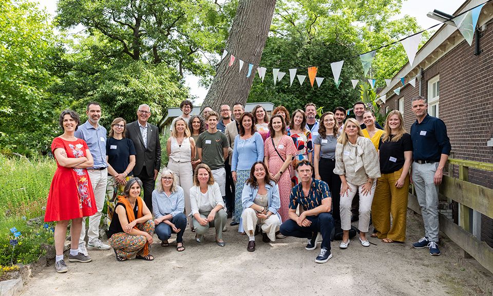 Groepsfoto van Zuid-Hollandse wethouders bij schoolpleinentop.