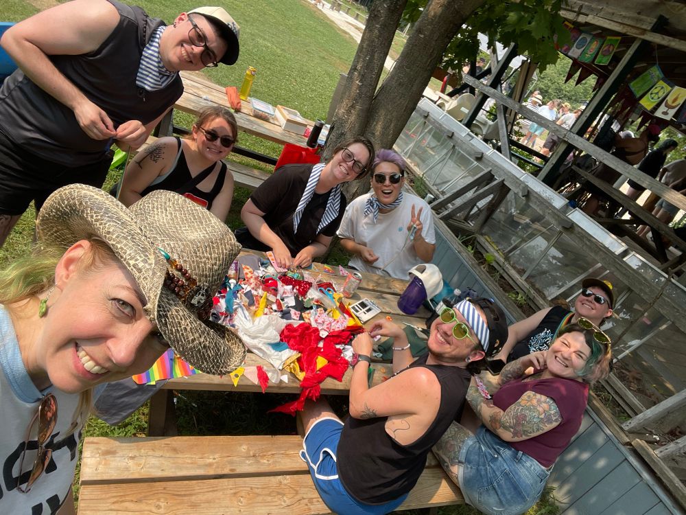 Pirates sitting at a picnic table covered with scraps of fabric.