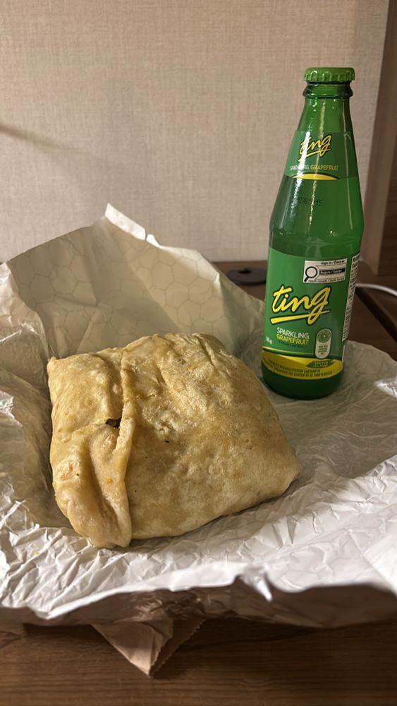 A chicken roti and bottle of Ting