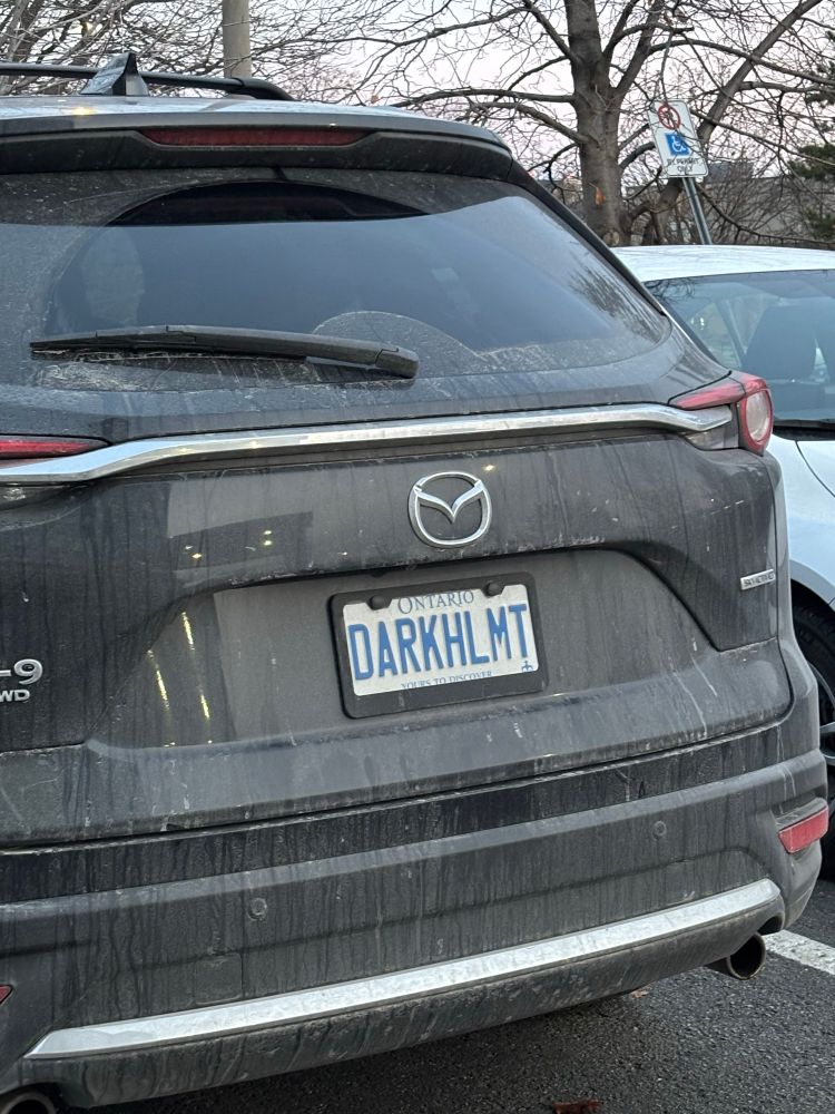 A black SUV with an Ontario license plate  that says “DARKHLMT”