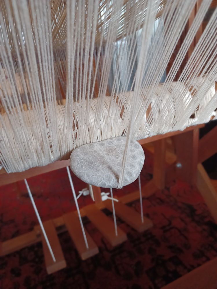 Petoskey stone holding down loose loom warp