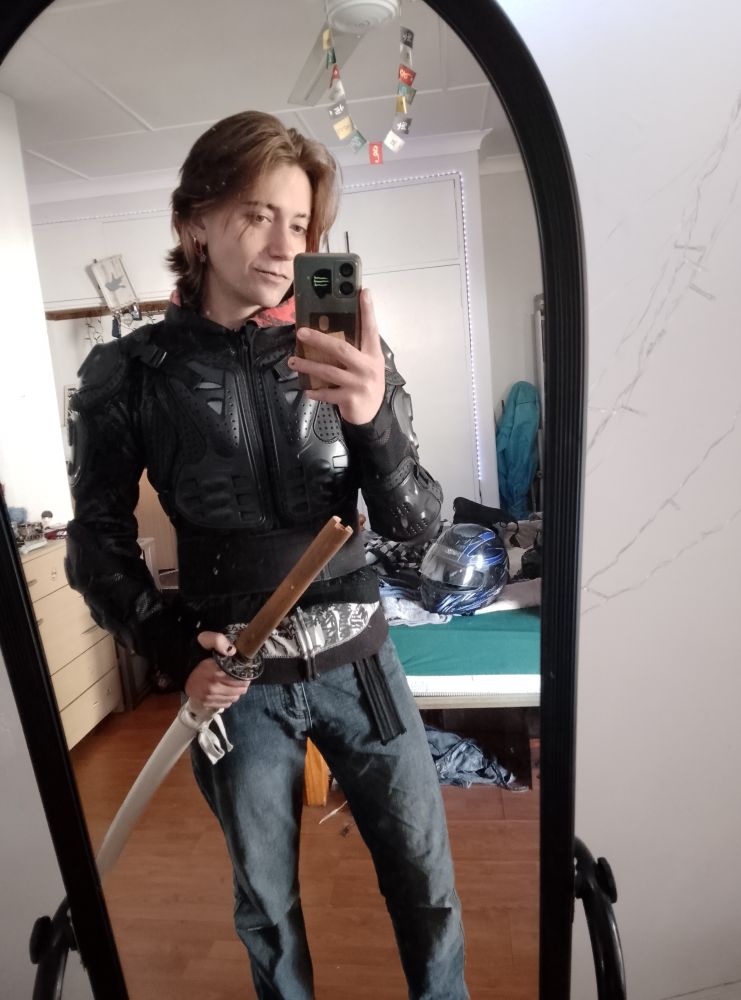 Me holding my sword while I wear my biking armour and jeans