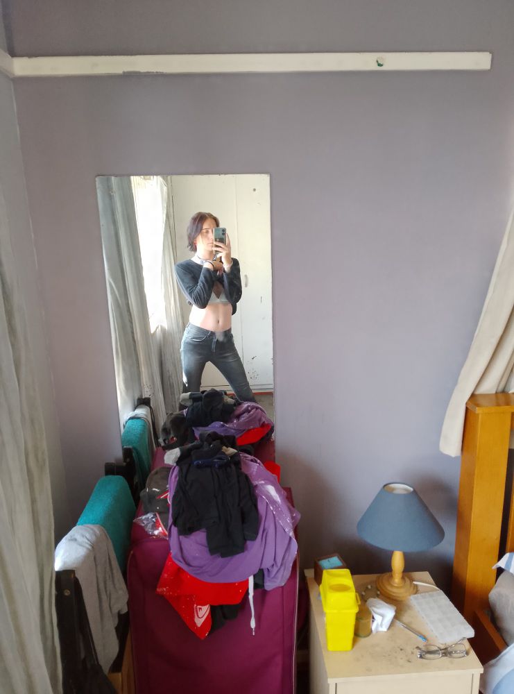 Me wearing tight skinny jeans and a black long sleeve. I'm lifting my shirt. 
