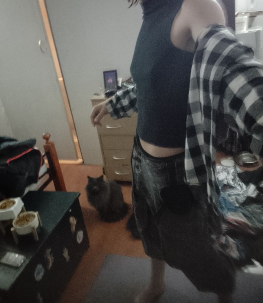 Me in a turtle neck vest and boho pants with a plead hoodie