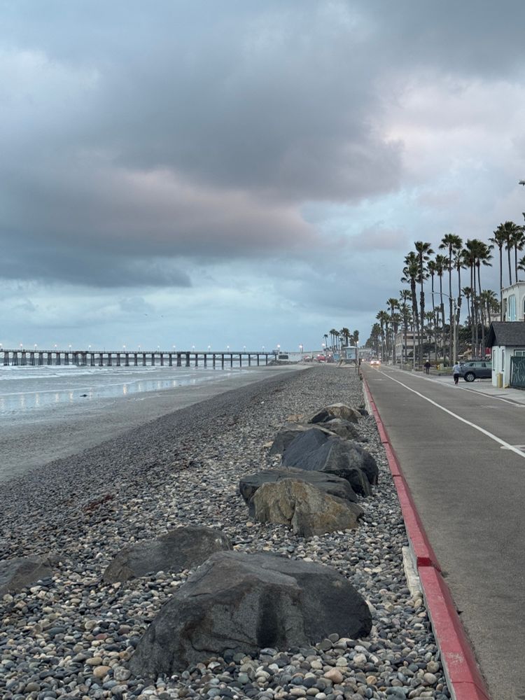 Oceanside beachfront with pier in the distance 