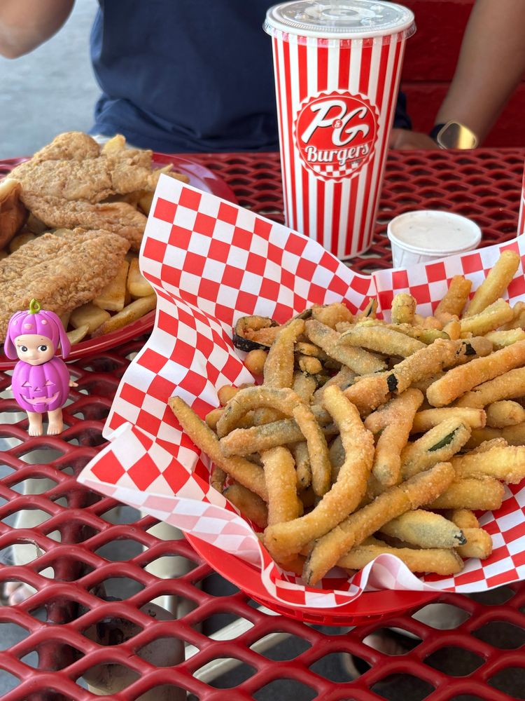 A picture taken by Kim of zucchini fries, chicken tenders, steak fries, strawberry rocky road shake and pistachio shake. Next to the food is a lone pumpkin lop ear Sonny angel. 