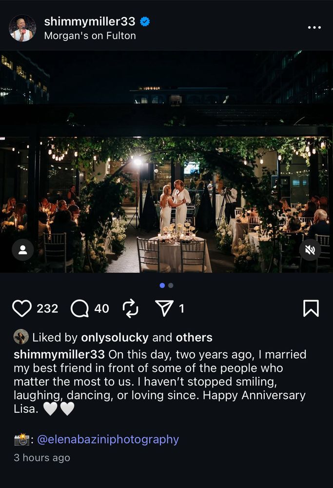 A romantic nighttime wedding reception at Morgan’s on Fulton. Two brides in white dresses stand under string lights and greenery, sharing a dance in the center of the courtyard. Guests sit at candlelit tables surrounding them, watching and smiling. The caption reads: “On this day, two years ago, I married my best friend in front of some of the people who matter the most to us. I haven’t stopped smiling, laughing, dancing, or loving since. Happy Anniversary Lisa. 🤍🤍 📸: @elenabaziniphotography.”