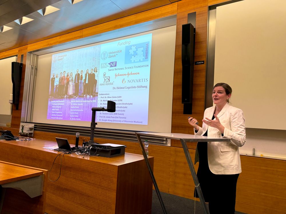 Prof. Nina Hartrampf in front of the lecture room showing the acknowledgment slide of her presentation.