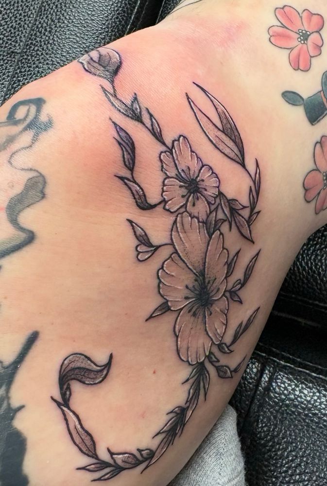 a tattoo of a floral scorpion on a knee/inner thigh 