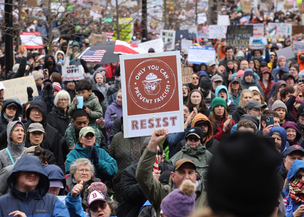 A close up shot of crowds on the plaza holding signs and rallying at the protest.