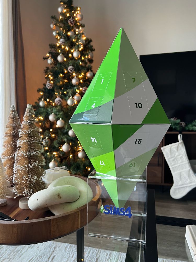 a plumbob-shaped advent calender on display in front of holiday decor.