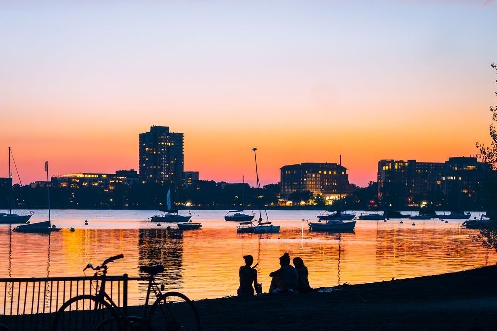 People on a Bde Maka Ska beach during a July 2025 sunset
