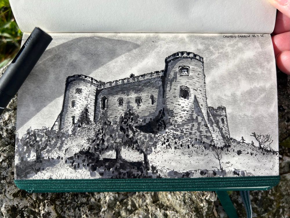 Pen and graphite sketch of Carew Castle, south Pembrokeshire. View is from below and to the west, with small trees and bushes in the foreground, with the west and north turrets of the castle rising beyond, connected by the west wall.