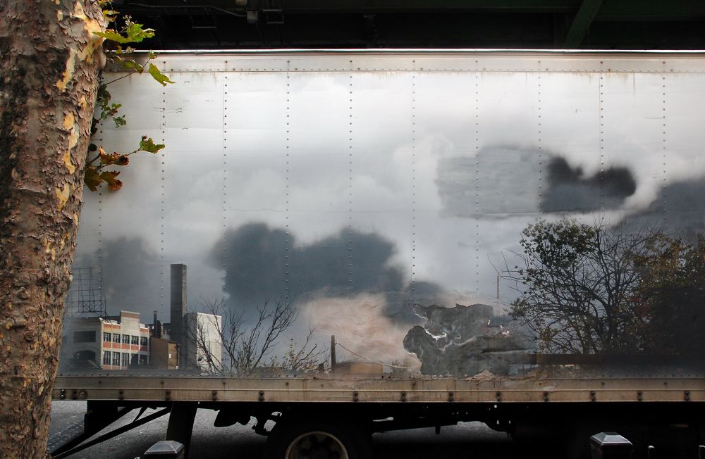 The side of a delivery truck with a city skyline superimposed on it 
