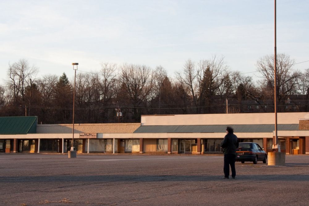 A man standing in a shuttered shopping mart
