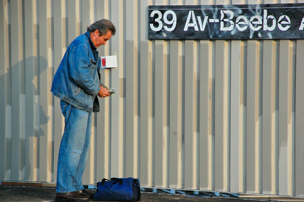 A man counting money at a subway station 