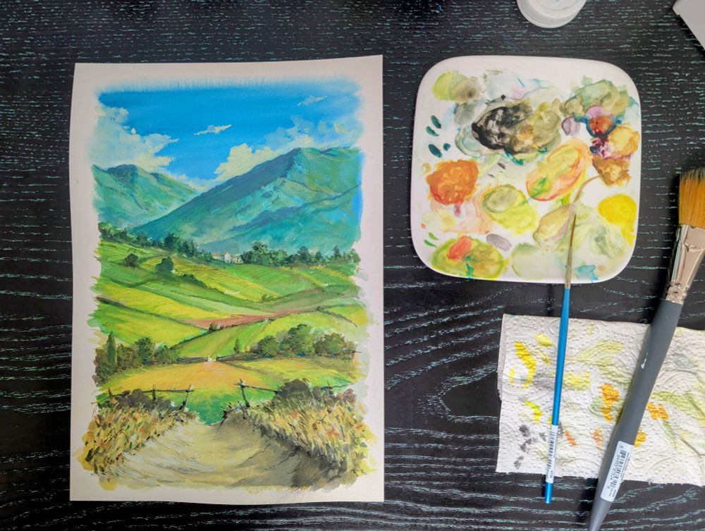 Photography of the painting above on a desk surrounded by painting supplies.