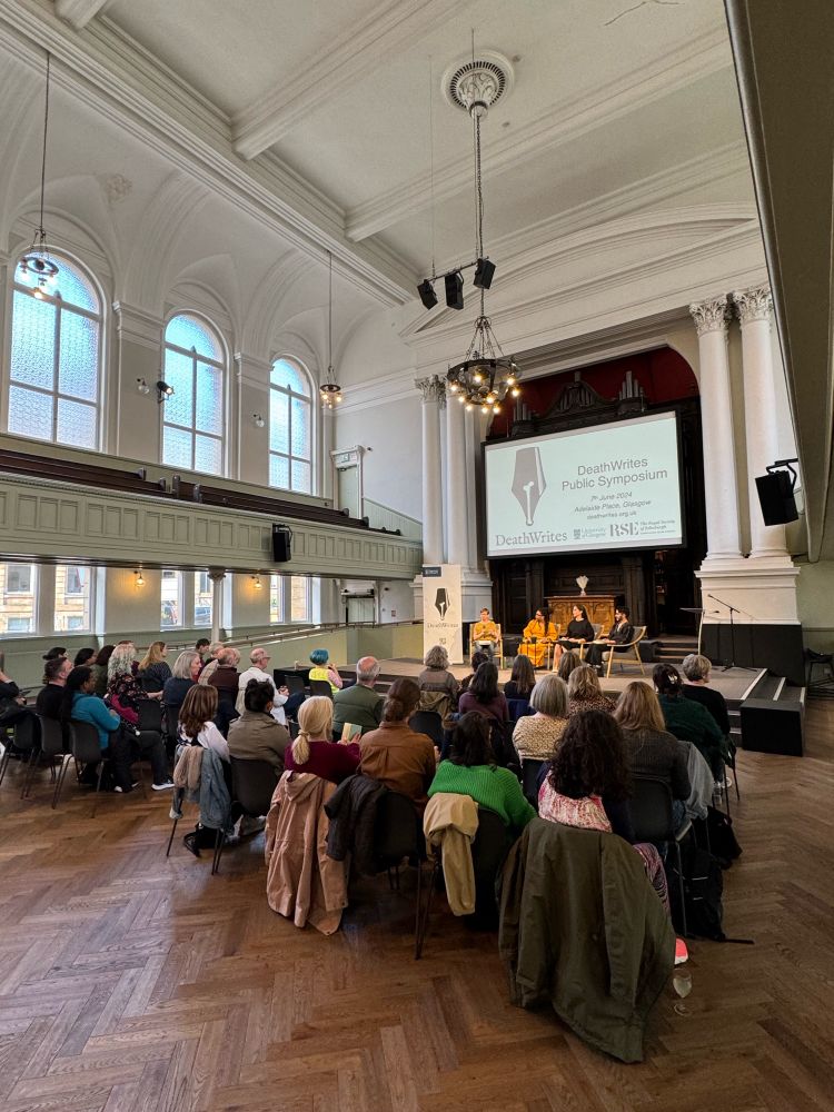 An audience attending an author panel at the DeathWrites Public Symposium in a grand hall