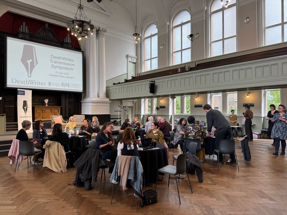 Around thirty writers in a large hall networking and chatting