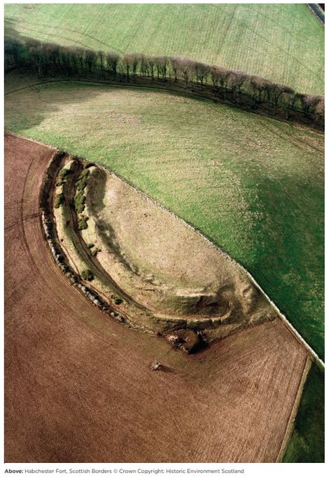 Aerial image of a hillfort showing two rings of defences, one half has been ploughed as shows barely a trace of the monument, the otherside hasn't and is very well defined.