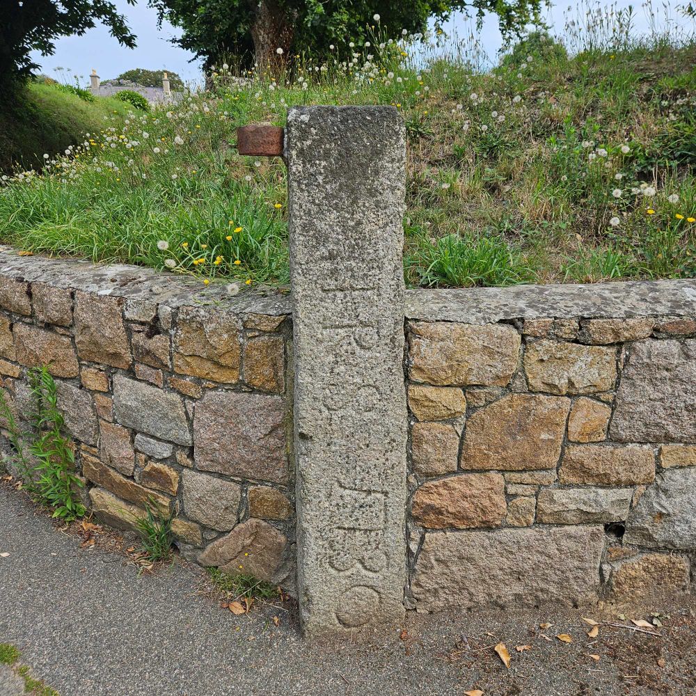 1.2m high granite gate post, set into wall, J P S 1730 possibly inscribed on it.