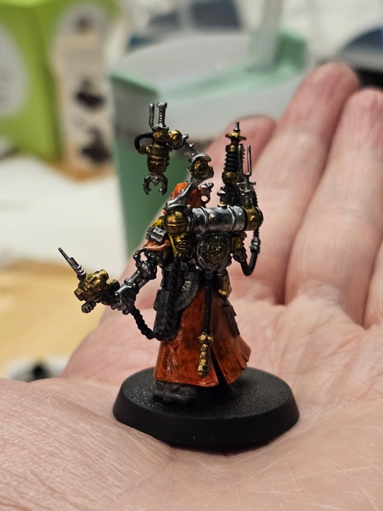 Warhammer technoarcheologist mini on an open hand