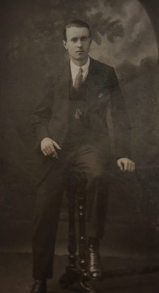 Posed sepia photo of a young man in a suit. Date circa 1900.