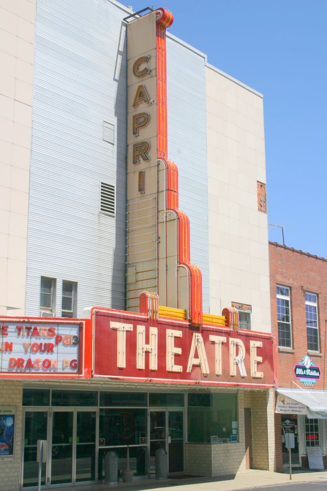 Image of a movie theater with an art deco-esque marquee with the words Capri Theatre written on it.