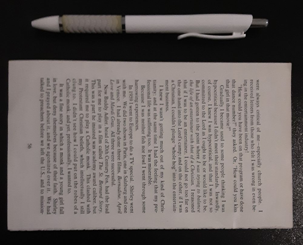 Image of a torn-out book page beneath a pen.
